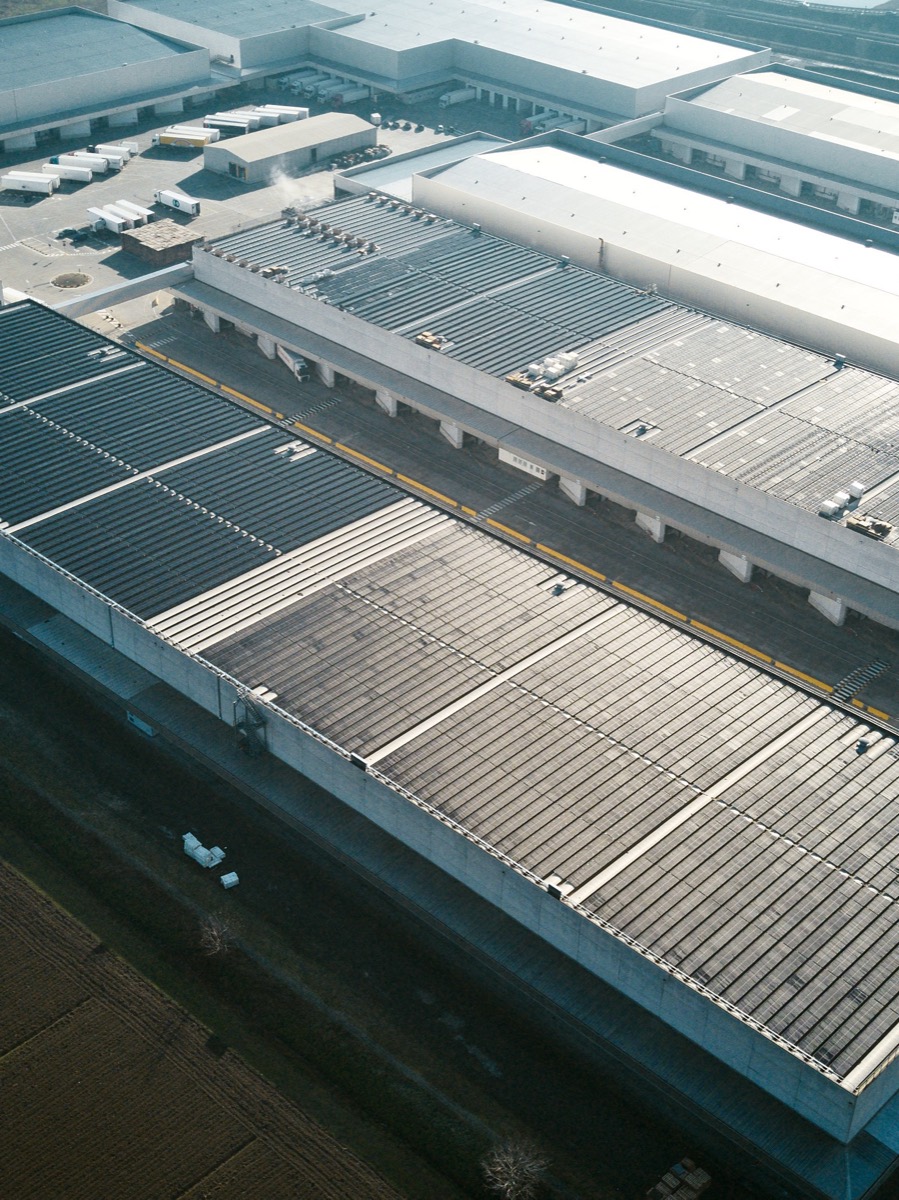 Veduta aerea di un grande complesso logistico-industriale con impianto fotovoltaico sulle coperture